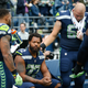 Running back Thomas Rawls, No. 34 of the Seattle Seahawks, stands with center Justin Britt, No. 68, to join defensive end Michael Bennett, No. 72, on the bench during the national anthem before the game at CenturyLink Field in Seattle on Sept. 17, 2017. (Otto Greule Jr./Getty Images)